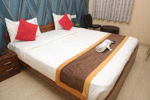 a bedroom with a large bed with a stuffed animal on it at virat inn in Bangalore +14 photos
