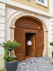 a large wooden door with an archway in a building at Városi Vendégház Szentendre in Szentendre