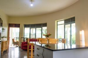 金贾Nile Retreat - Luxury Villa in Jinja的配有桌椅的厨房和客厅 更多19张照片