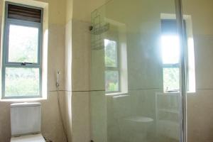 金贾Nile Retreat - Luxury Villa in Jinja的带淋浴、马桶和窗户的浴室