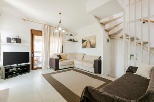 a living room with a couch and a tv at Delmare Delia maisonette in Yerakiní
