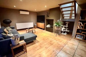 een woonkamer met een blauwe bank en een wit scherm bij Villa d'architecte avec vue imprenable in Péruwelz