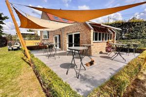 een terras met een tafel en een hond onder een tent bij Villa d'architecte avec vue imprenable in Péruwelz