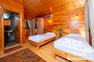 a room with two beds in a wooden cabin at Çıralı Nun Bungalove in Cıralı