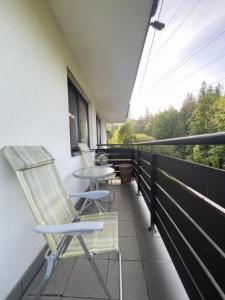 2 chaises et une table sur un balcon dans l'établissement Apartament Idylla, à Zakopane