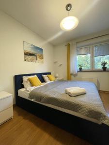 Apartament Idylla في زاكوباني: غرفة نوم بسرير كبير مع مخدات صفراء