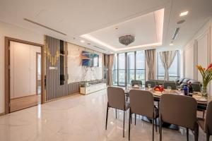 a dining room with a long table and chairs at LANDMARK 81 Condotel Garden Bay in Ho Chi Minh City