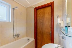 a bathroom with a shower and a wooden door at Kosmos Hotel St4 in Agios Stefanos in Agios Stefanos