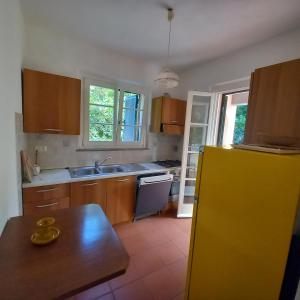 a kitchen with wooden cabinets and a yellow refrigerator at la raganella - appartamento in Procchio