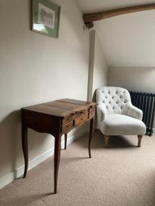 un tavolo in legno e una sedia in una stanza di Chambres & Table d'hôtes de La Vieille Ferme a Salon-la-Tour Altre 21 foto