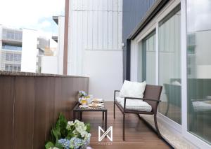 uma pequena varanda com uma cadeira e uma mesa em MyStay - D Maria Apartments em Vila Nova de Famalicão