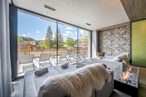 a living room with a couch and a large window at Summit Seefeld in Seefeld in Tirol