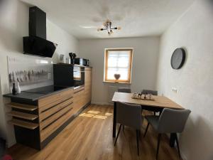 eine Küche und ein Esszimmer mit einem Tisch und einer Theke in der Unterkunft Ferienwohnung Zauberwald in Waldkirchen