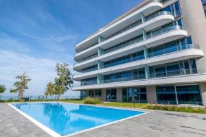 a building with a swimming pool in front of it at Wave Luxury Apartment in Siófok