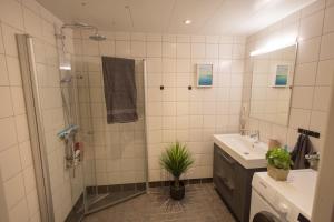 y baño con ducha, lavabo y espejo. en Modern Apartment - Amazing Terrace and Fjord View, Close to City Center en Bergen