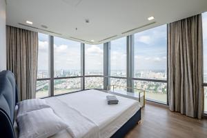 a bedroom with a bed and large windows at Free Pickup Airport-LANDMARK 81 Condotel Center Suite in Ho Chi Minh City