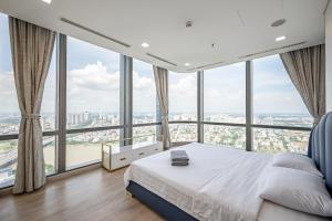 a bedroom with a bed and large windows at LANDMARK 81 Condotel Garden Bay in Ho Chi Minh City