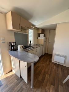 a small kitchen with a table in a room at CAMPING DU PHARE d OPALE MOBILE HOME J10 in Le Portel