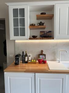 a kitchen counter with white cabinets and a sink at Sunset Appartment in Golem