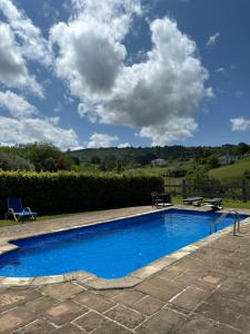 ein blauer Pool mit blauem Himmel und Wolken in der Unterkunft Caserio Kamirune in Laukiz