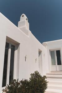 un edificio blanco con una escalera empinada en la parte delantera en Mykonos Pantheon, en Playa Kalo Livadi