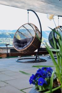 una sedia a dondolo su un patio fiorito di Quality Hotel Waterfront ad Ålesund