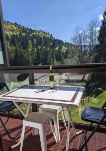 - une table avec une bouteille de vin sur le balcon dans l'établissement Studio Gil La Bresse Hohneck, à La Bresse