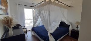 um quarto com uma cama de dossel e uma janela em Cap Saint Martin Marina em Cap d'Agde
