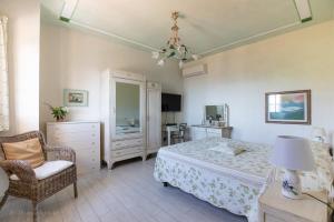 a bedroom with a bed and a chair at Villa Romantica Sea View in Camaiore +75 photos