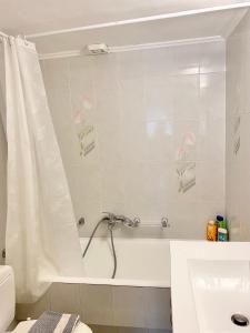 a bathroom with a tub and a shower curtain at Villa Alexandros in Porto Heli