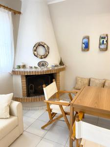 a living room with a table and a fireplace at Villa Alexandros in Porto Heli