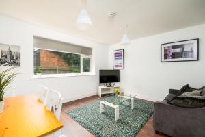 a living room with a couch and a table at K Suites - Station Road in Hinckley