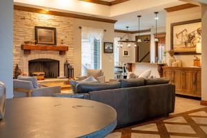 ein Wohnzimmer mit Sofas und einem Kamin in der Unterkunft Peaceful Luxurious Ranch Family Reunion in Wanette
