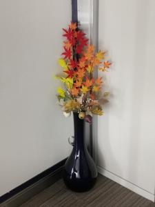 a black vase with autumn leaves in it at Business Hotel Azuma in Hanno