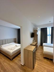 a bedroom with two beds and a television in it at GL Hotel Ksamil in Ksamil