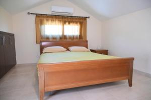 a bedroom with a wooden bed with a window at Kakopetria's Holiday House in Kakopetria