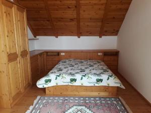 a bedroom with a bed in a room with wooden ceilings at Zalavég falusi ház in Zalavég
