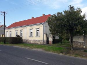 a white house with a red roof on a street at Zalavég falusi ház in Zalavég