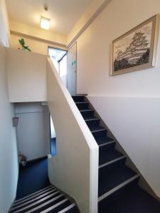 una escalera en una casa con suelo azul en Business Hotel Azuma en Hanno
