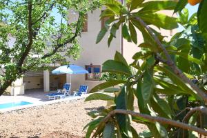 uma casa com piscina e duas cadeiras e um guarda-sol em Kakopetria's Holiday House em Kakopetria