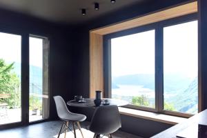 a dining room with a table and chairs and windows at La casa di Cesare in Rogno