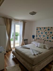 a bedroom with a large bed and a window at Apartment Lučka in Rab