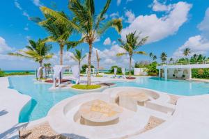 uma piscina no resort com palmeiras em Ycona Eco-Luxury Resort, Zanzibar em Dikoni