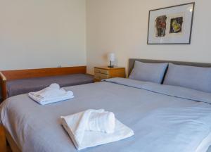 een bed met twee handdoeken bovenop bij Florina House - Spacious with 2 Bedrooms and mountain view in Florina