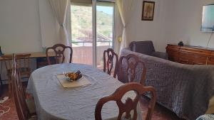 a living room with a table and chairs and a couch at Apartamento Peñuelas Torrox in Torrox