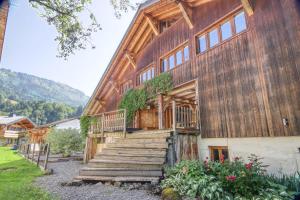 een houten huis met een trap daarheen bij Ferme du Ciel in Samoëns