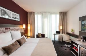 ein Hotelzimmer mit einem Bett und einem Schreibtisch in der Unterkunft Leonardo Royal Hotel Munich in München