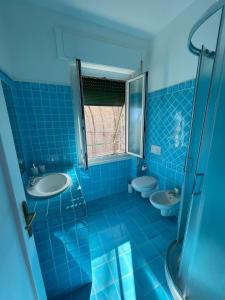 a blue tiled bathroom with two sinks and a window at Casa Aysha in Bogliasco +23 photos