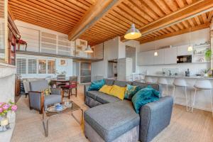 Una sala de estar con un sofá y una cocina. en GuestReady - Canut Typique avec vue sur Lyon, en Fourvière