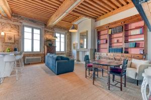 una sala de estar con una mesa y un sofá en GuestReady - Canut Typique avec vue sur Lyon, en Fourvière